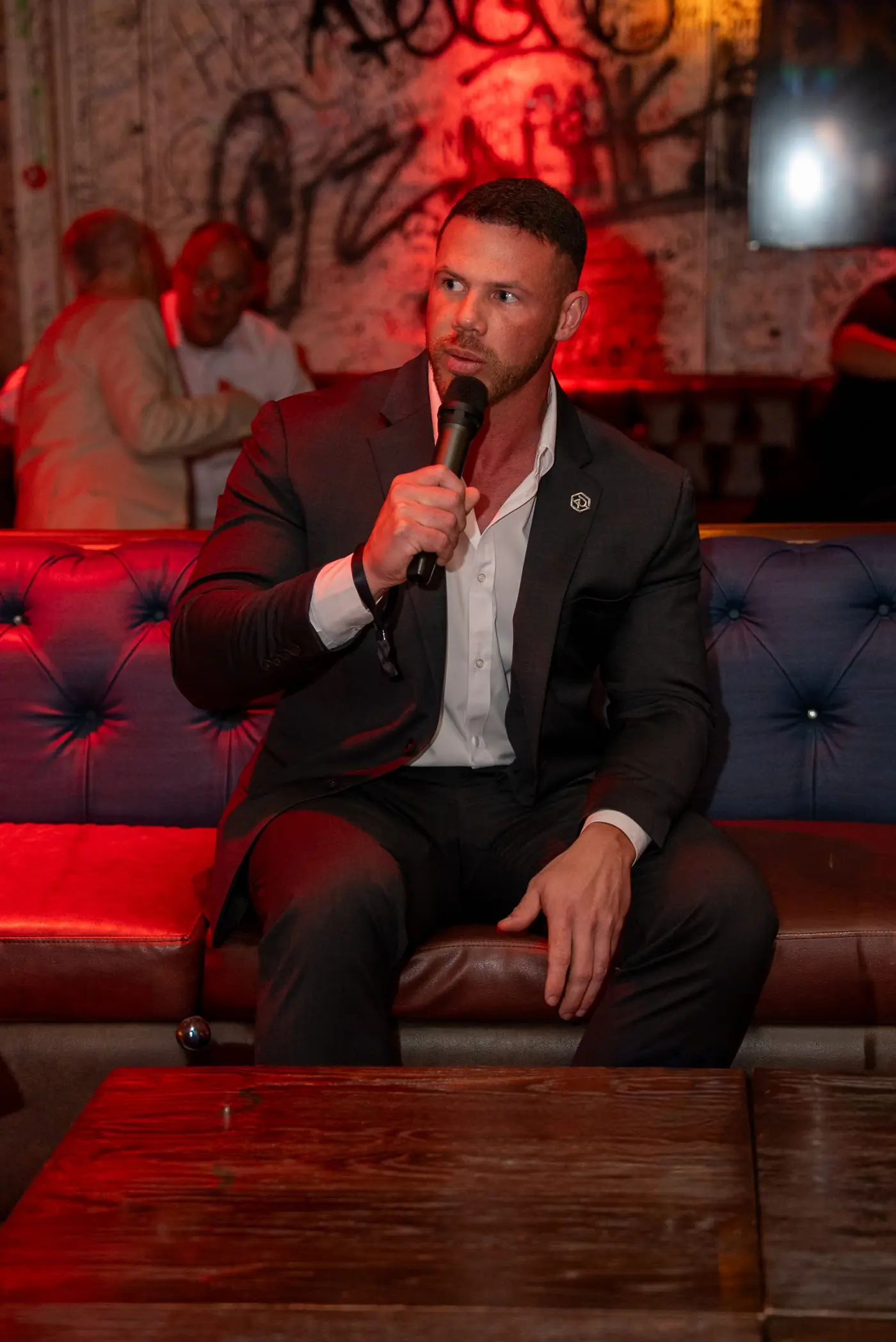 Jake Claver seated with a microphone during an evening session