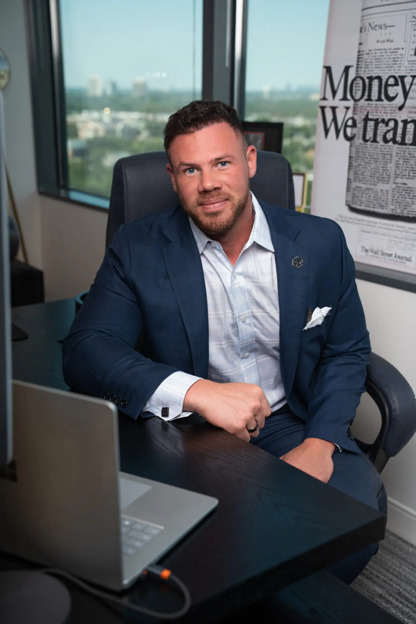 Jake Claver at his desk beside a framed newspaper front page