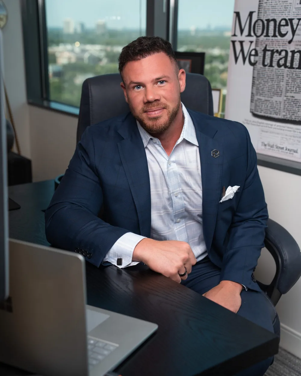 Jake Claver at his desk beside a framed newspaper front page